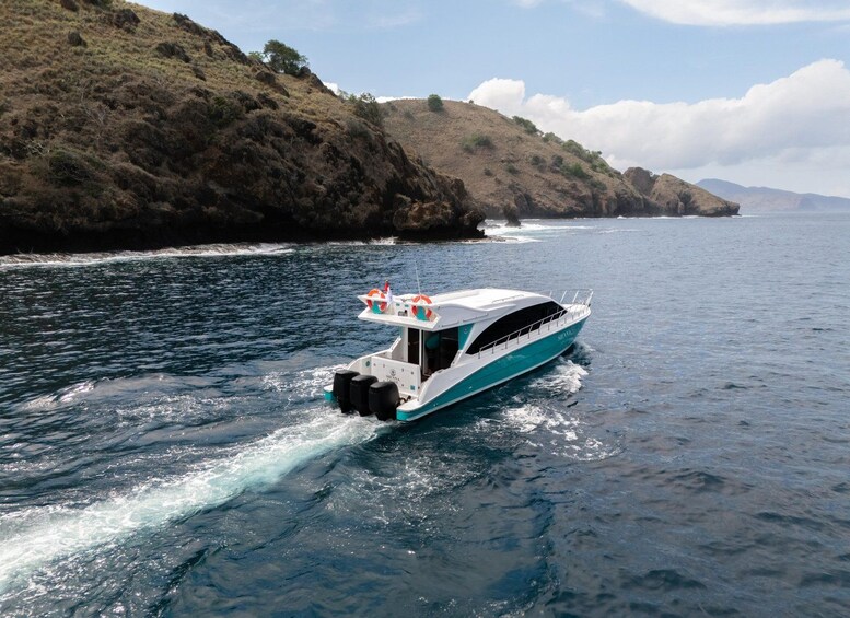 Un bateau sur une étendue d’eau, avec une côte rocheuse en arrière-plan. 1