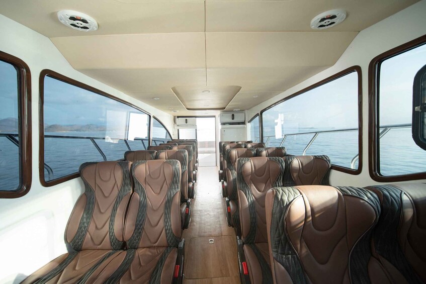 L'intérieur d'un bateau, avec des rangées de sièges en cuir et de grandes fenêtres. 5