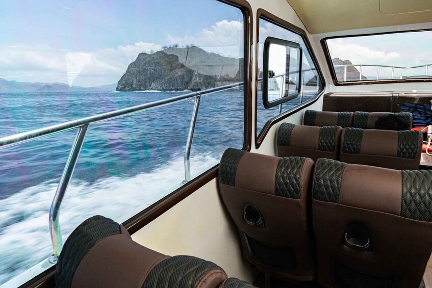 L'intérieur d'un bateau, avec vue sur l'océan et une île rocheuse. 2