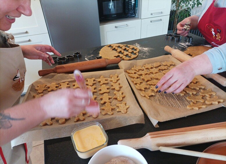 A kitchen with people making gingerbread cookies. 5