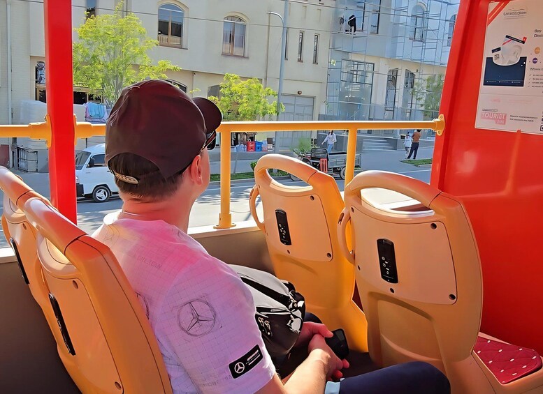 A person seated in a bus, holding a smartphone. 5
