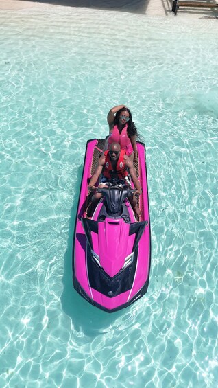 Deux personnes sur un jet ski rose, dans une piscine à l’eau cristalline et d’un bleu éclatant. 3