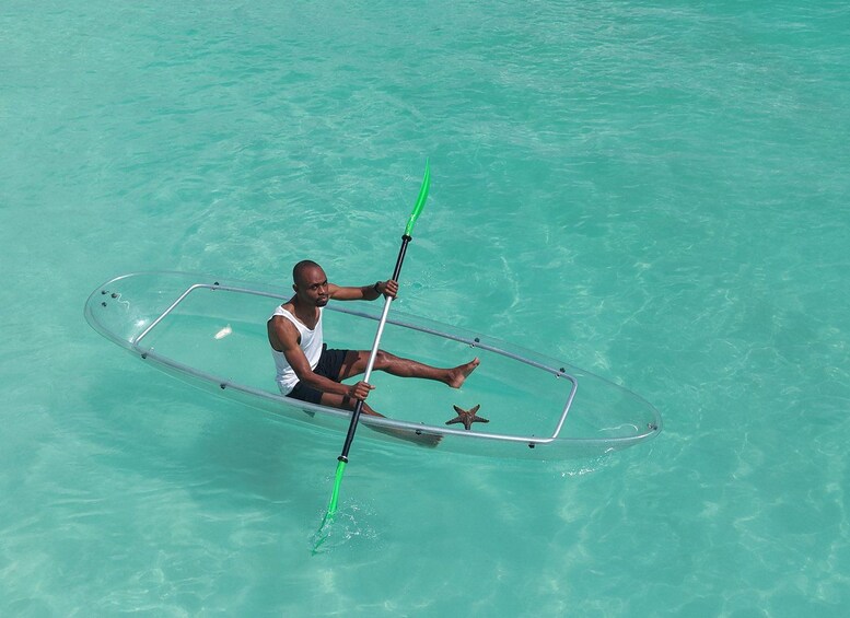 Une personne pagaye dans un kayak transparent, sur une eau turquoise et cristalline. 2