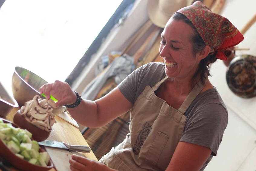 A person chopping mushrooms with a knife on a cutting board. 1