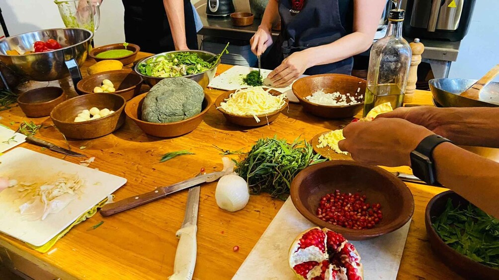 A kitchen with various ingredients and utensils, including bowls of vegetables, a knife, and a cutting board. 2