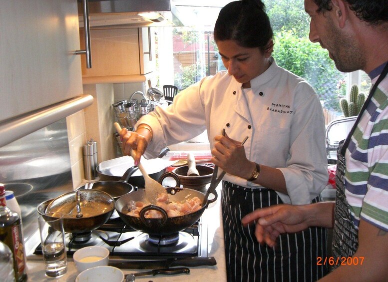 A chef cooking in a kitchen with a stove, pots, and a window showing greenery outside. 5