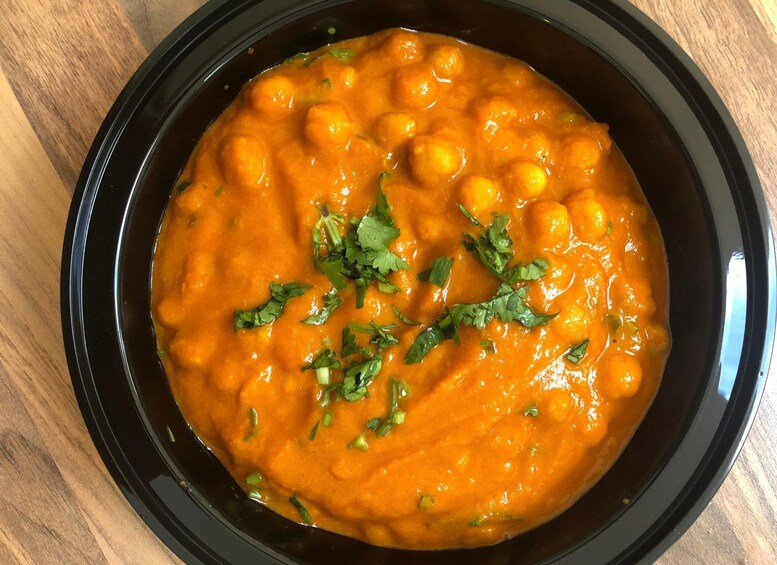 A bowl of chickpea curry garnished with cilantro. 4