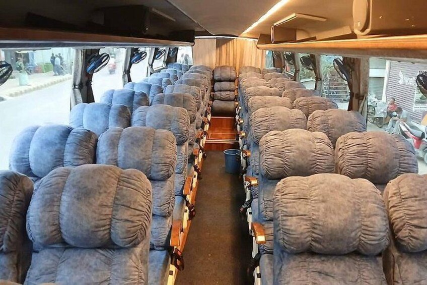 A train interior with rows of plush seats and overhead luggage racks. 5