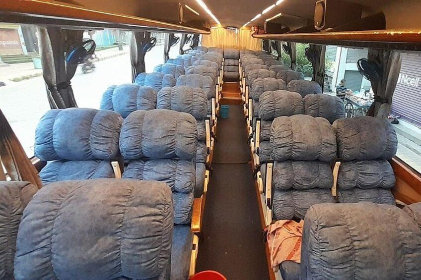A train interior with rows of blue cushioned seats and wooden benches. 4