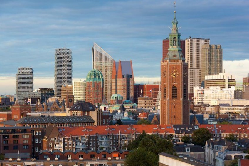 A cityscape with a prominent clock tower, modern buildings, and historic architecture. 1