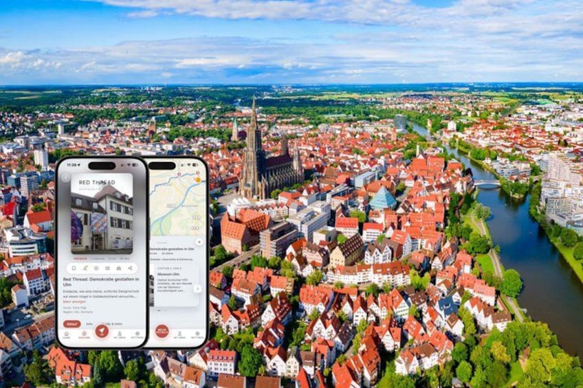 A cityscape with a river, historic buildings, and a church spire. 1