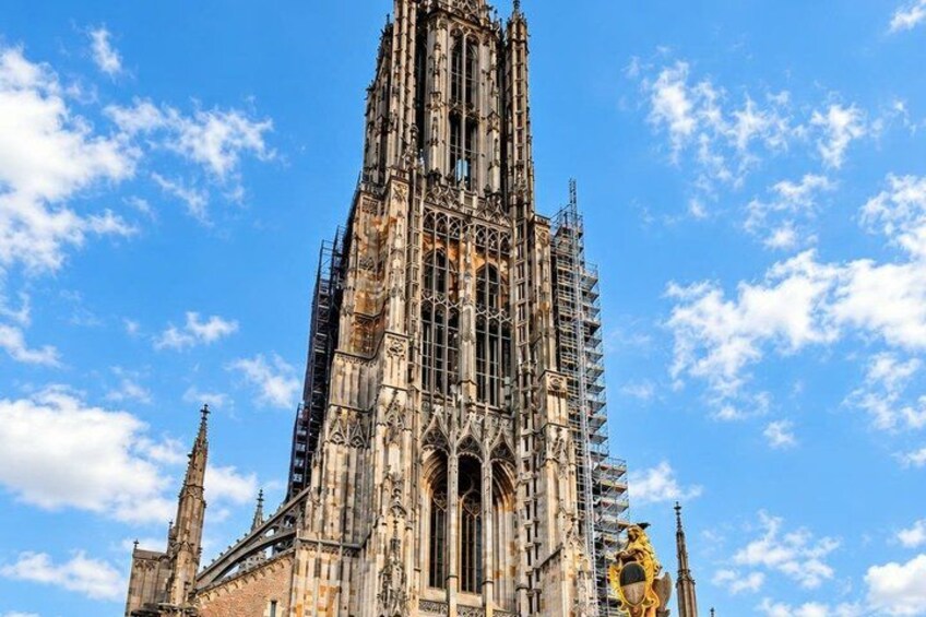 A historic cathedral with intricate architecture, scaffolding, and a clear blue sky. 2