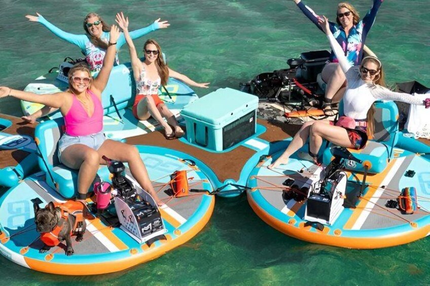 Two inflatable boats with people on them, surrounded by clear water. 4