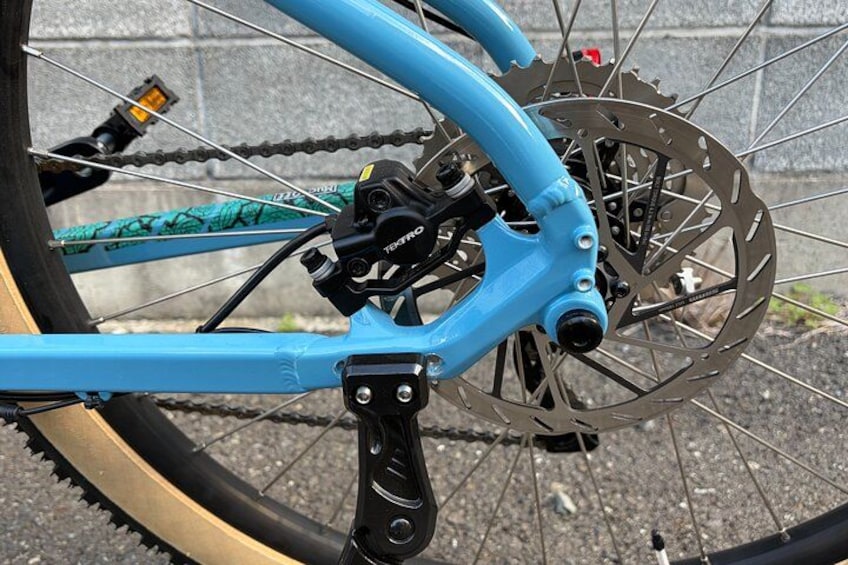 A blue bicycle with a disc brake system and a rear derailleur. 4