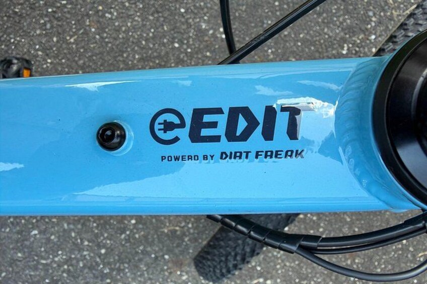 A blue bicycle frame with the text 'EDIT' and 'POWERED BY DIRT FREAK' on it. 2
