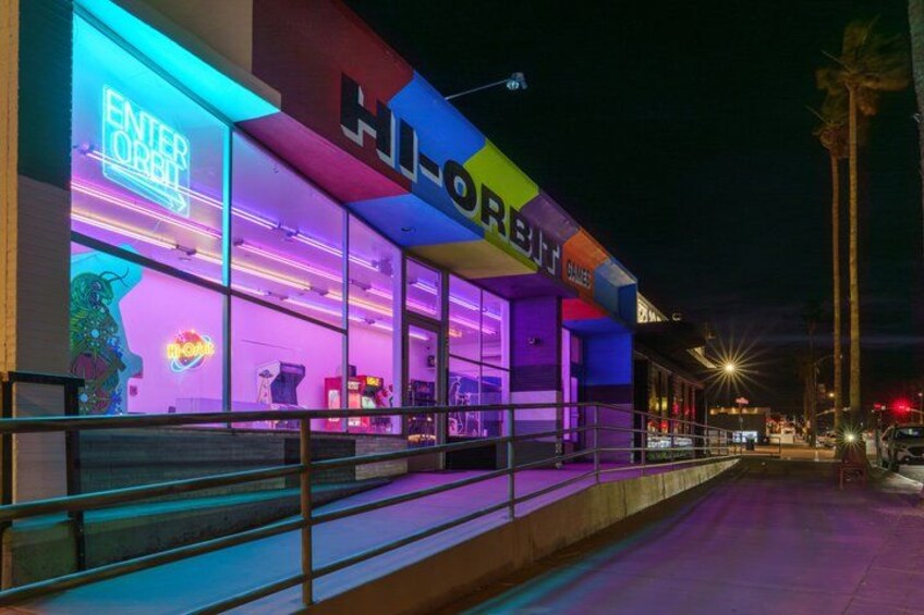 A brightly lit arcade with neon signs and a colorful facade. 4
