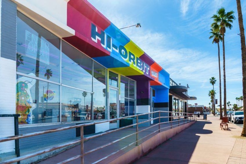 A colorful storefront with the sign 'HI-ORIENT' and a pedestrian walkway. 3
