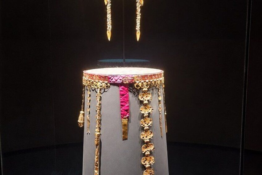 A drum with intricate gold and pink decorations. 3