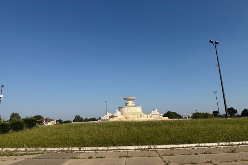 A white stupa on a grassy hill with a clear sky. 4