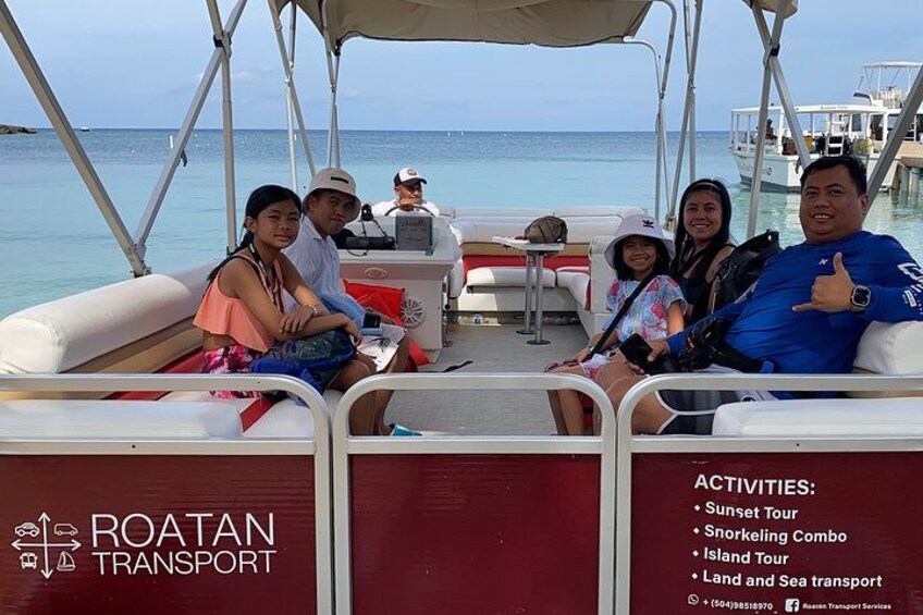 A boat with people on board, a clear view of the sea, and a dock in the background. 5