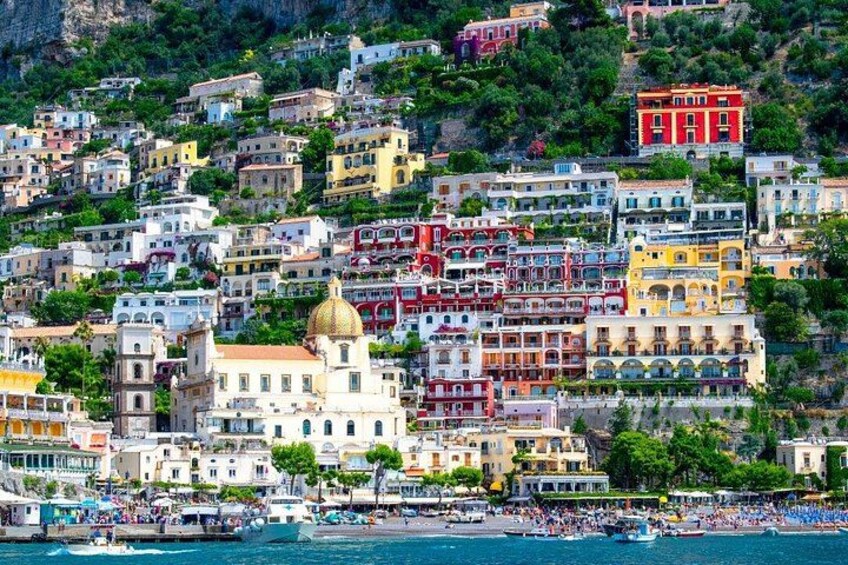 A coastal town with colorful buildings, a prominent church with a golden dome, and a busy waterfront with boats and people. 5