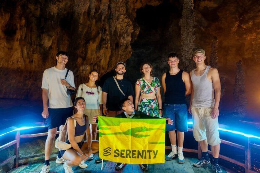 A group of people standing in a cave with a banner. 1