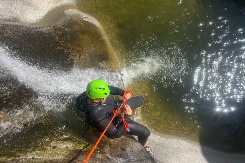 A person climbing a rock with a helmet and harness. 5