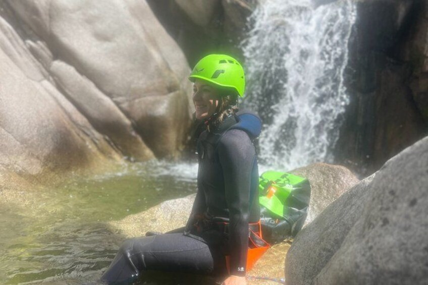 A person in a wetsuit and helmet near a waterfall. 4