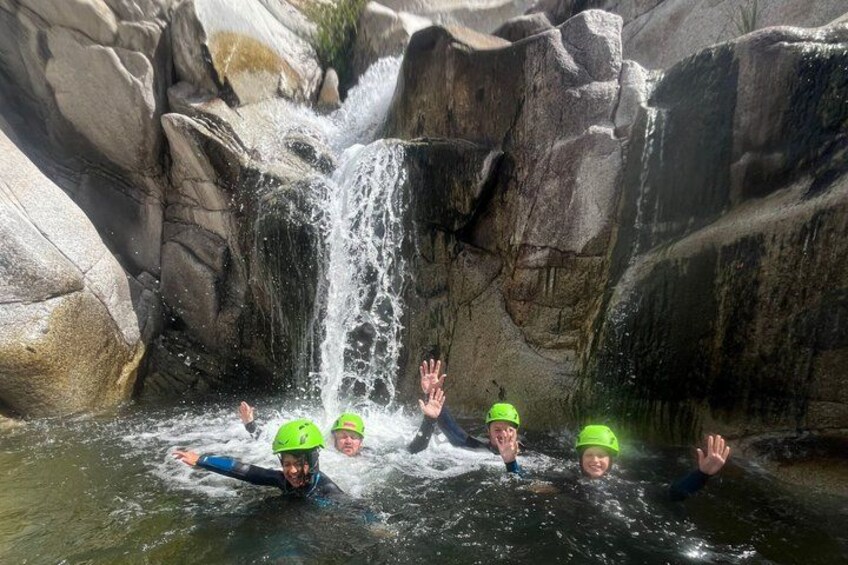 People in a water body with a waterfall. 1