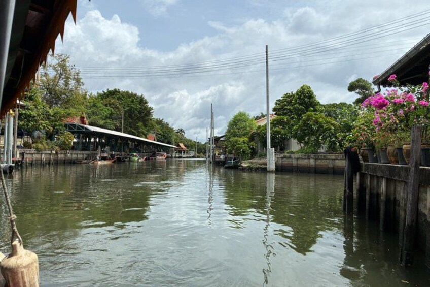 A calm river with boats, wooden houses, and lush greenery. 5