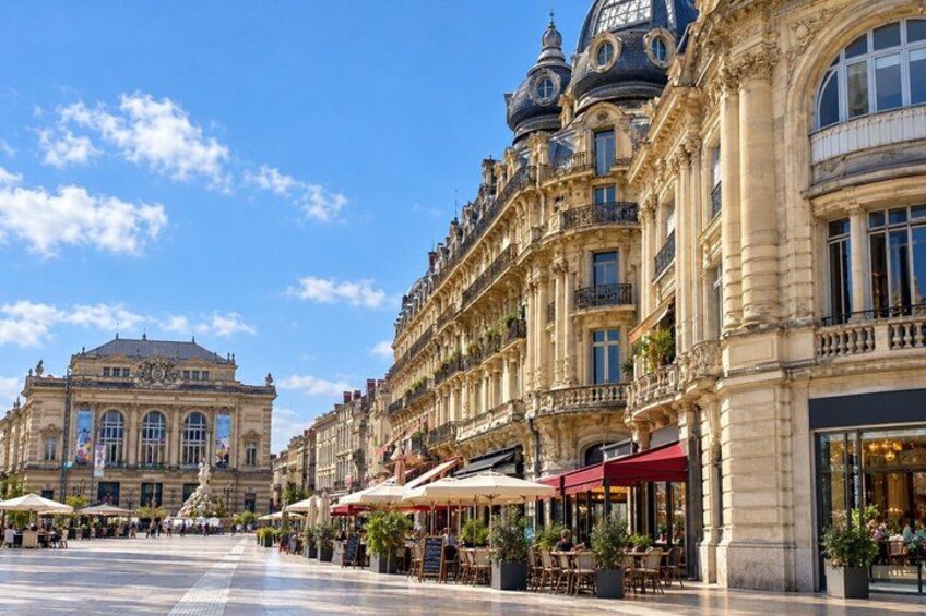 A historic European square with ornate buildings, outdoor cafes, and a large open plaza. 2