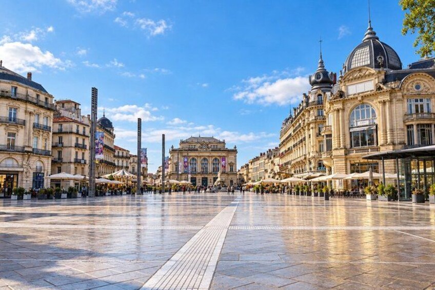 A wide, open square with historic buildings, a central monument, and a clear sky. 3