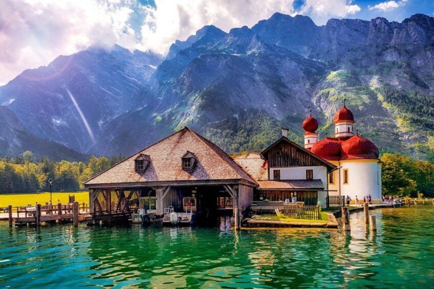 A lakeside building with a red dome and a wooden structure. 1