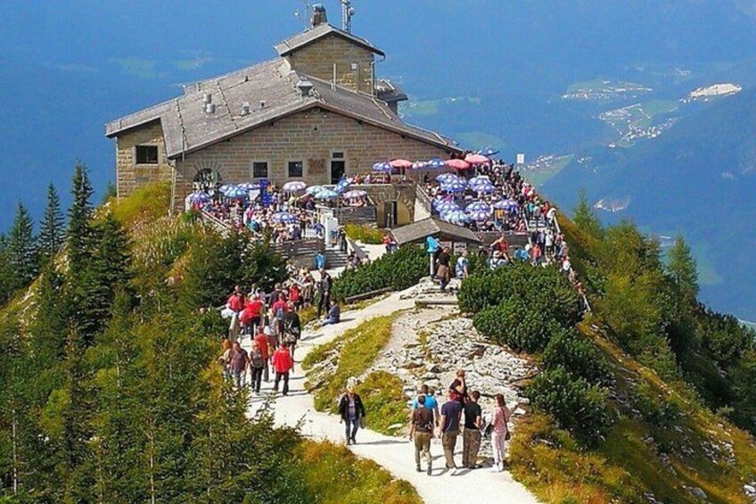 A mountain lodge with a stone building and a pathway leading to it. 3