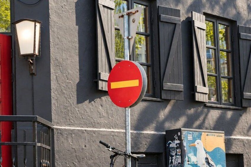A red 'no entry' sign, a building with dark shutters, a street lamp, and a bicycle. 3