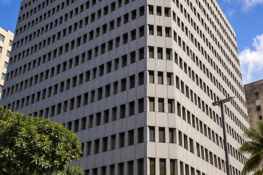 A tall, modern building with a grid of windows and a curved corner. 5