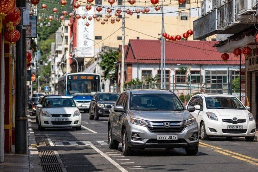 A street with cars, a bus, and red lanterns. 4