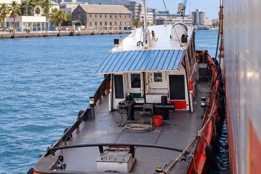 A boat with a blue roof, a small cabin, and a dock in the background. 2