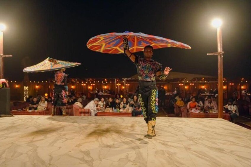 A performer on a stage with an audience seated around. 4