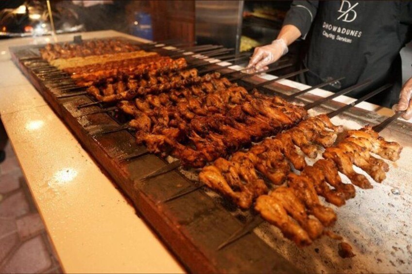 A grill with various meats being cooked. 5