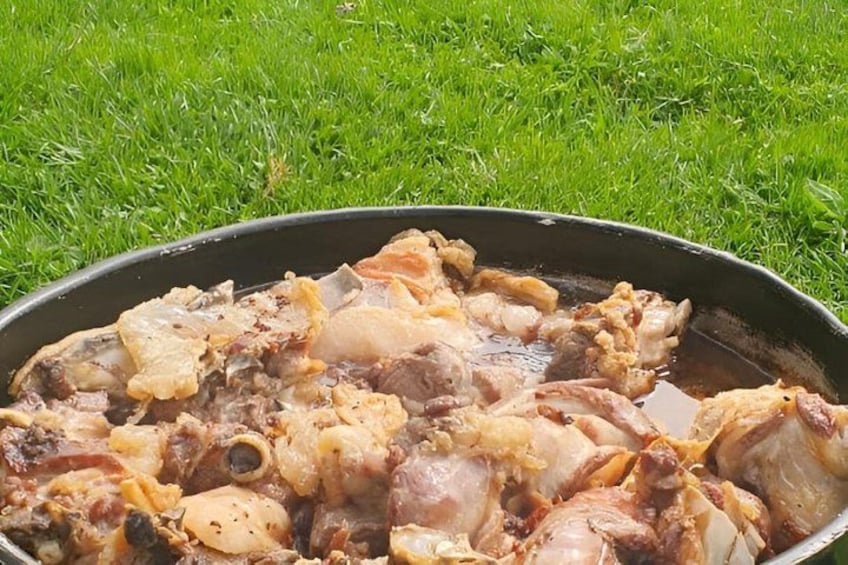 A pan with raw meat on a grassy surface. 3
