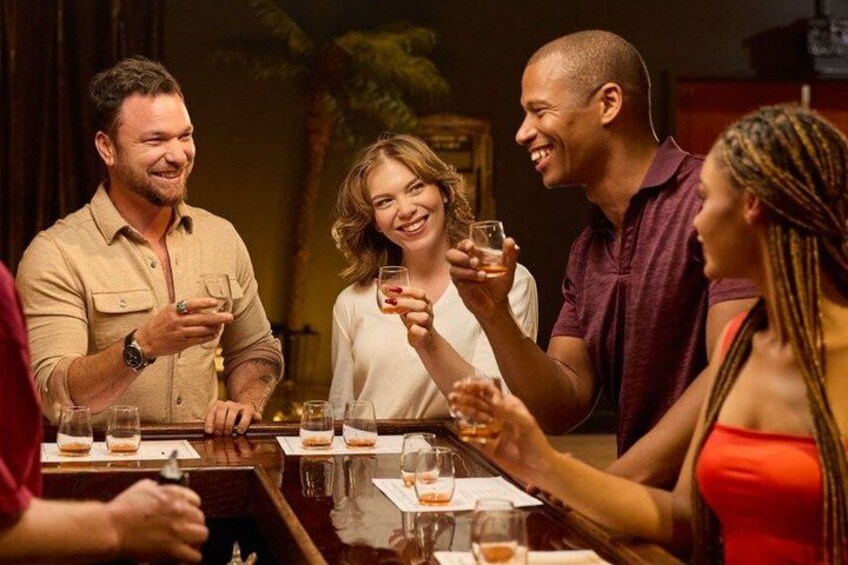 A group of people sitting around a table with drinks, engaged in conversation. 1