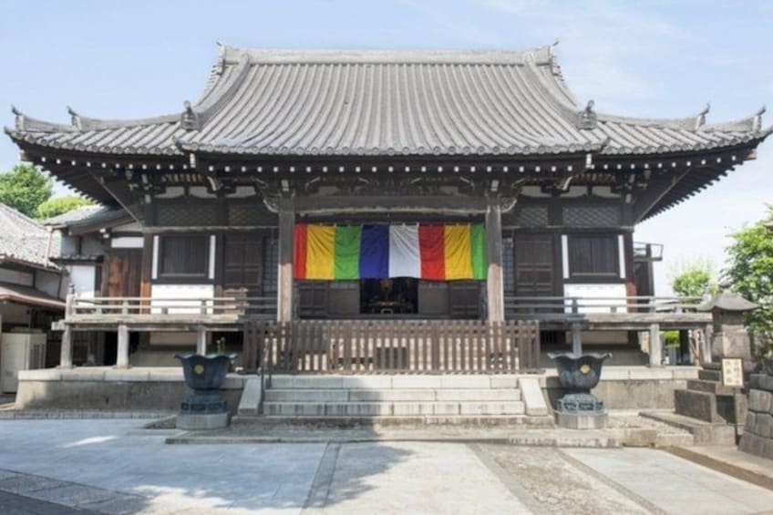 A traditional Korean building with a tiled roof, a wooden fence, and a colorful flag. 5