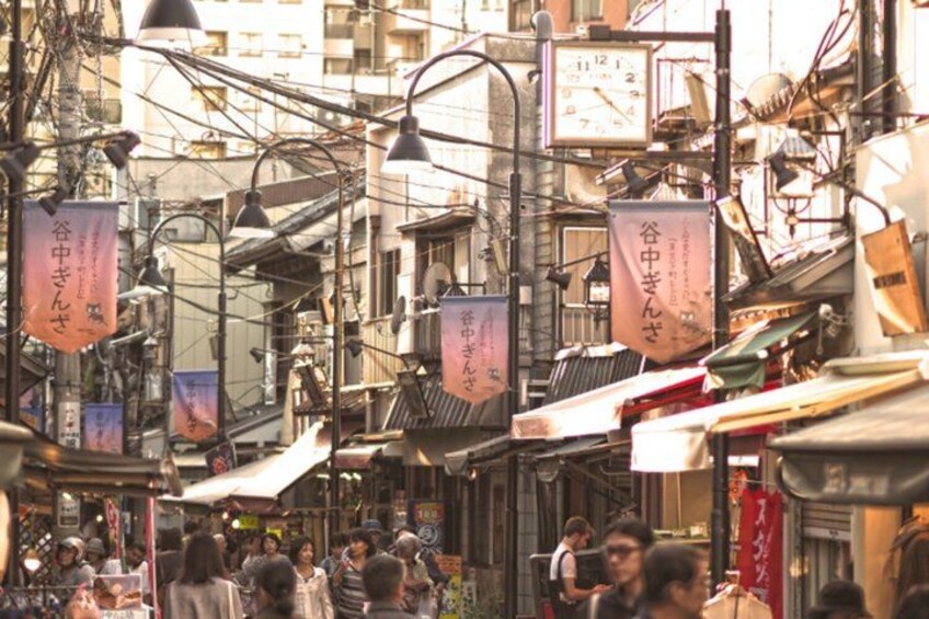 A crowded market street with hanging signs and traditional buildings. 3