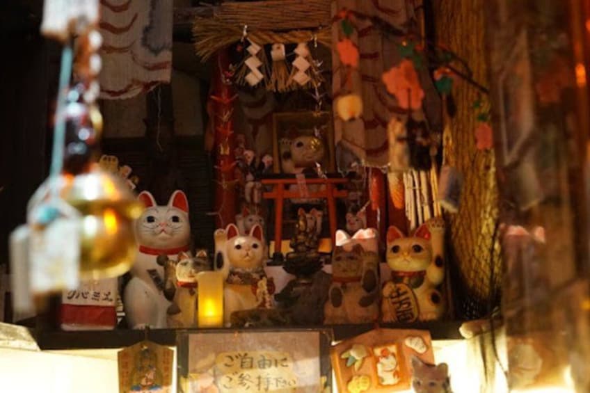 A shrine with various cat figurines and traditional decorations. 2