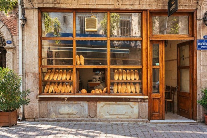 A bakery with a display of bread in the window. 5