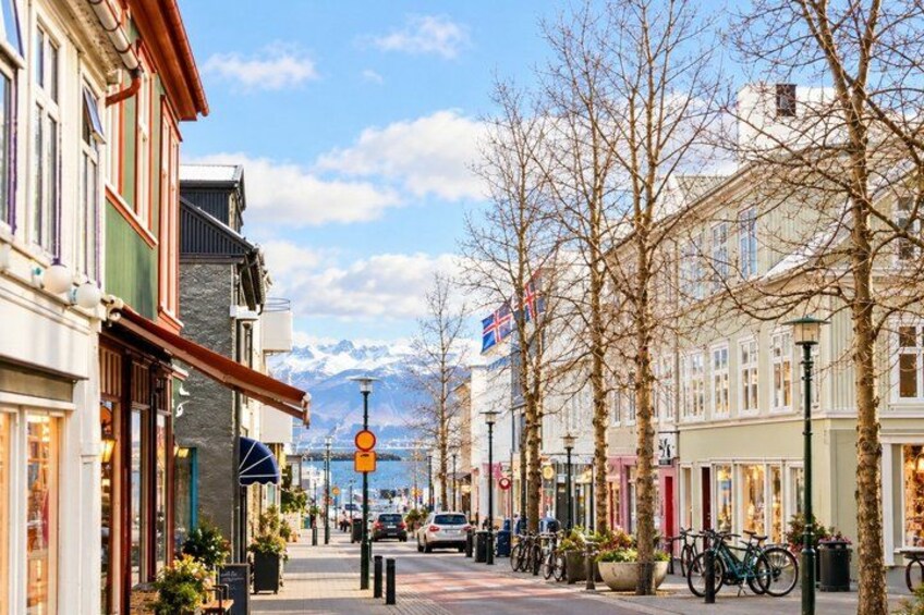 A street lined with buildings, bicycles, and a flag. 5