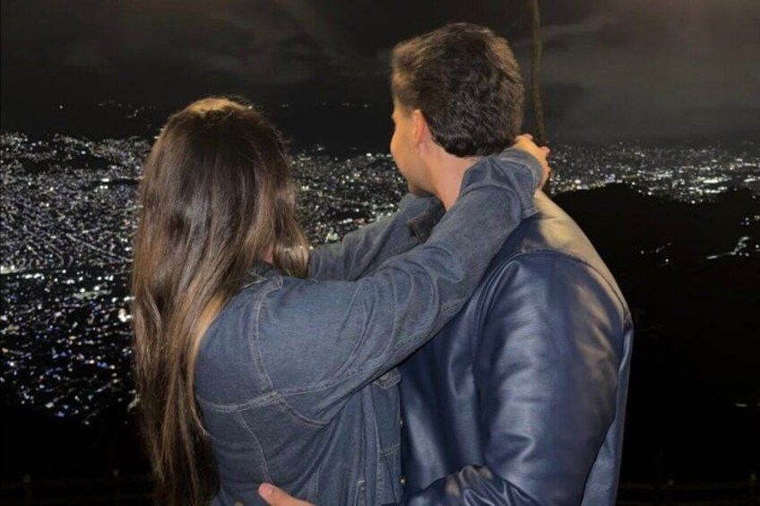 A couple embracing with a cityscape in the background. 2