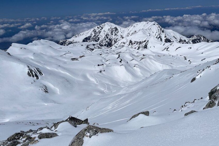 A snow-covered mountain range with rugged terrain and a clear sky. 3