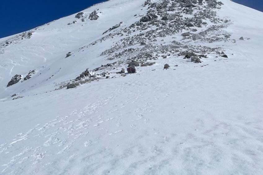 A snow-covered mountain slope with rocky outcrops. 5